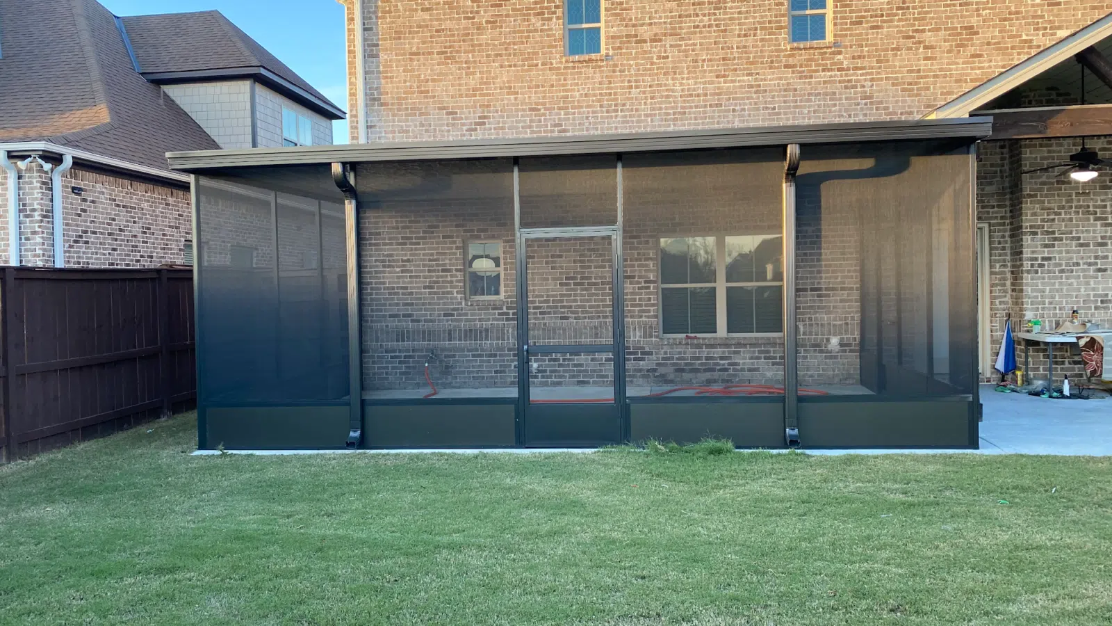 New black aluminum screen room enclosure against a brick home — Three Rivers Aluminum Awnings, LLC. in Dothan